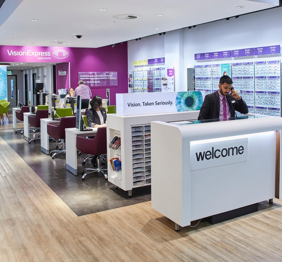 Interior of a Vision Express store with four staff members.