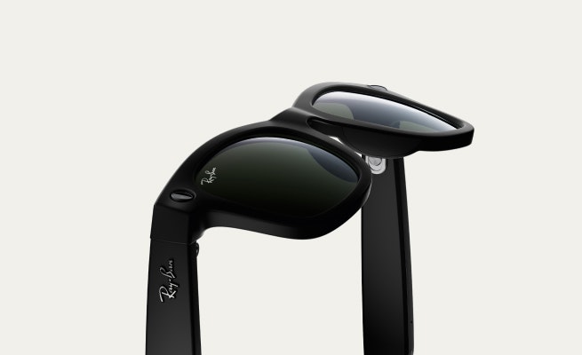 Gafas de sol Ray-Ban negras con diseño clásico Wayfarer, mostrando las bisagras abiertas y el logotipo grabado en las patillas.