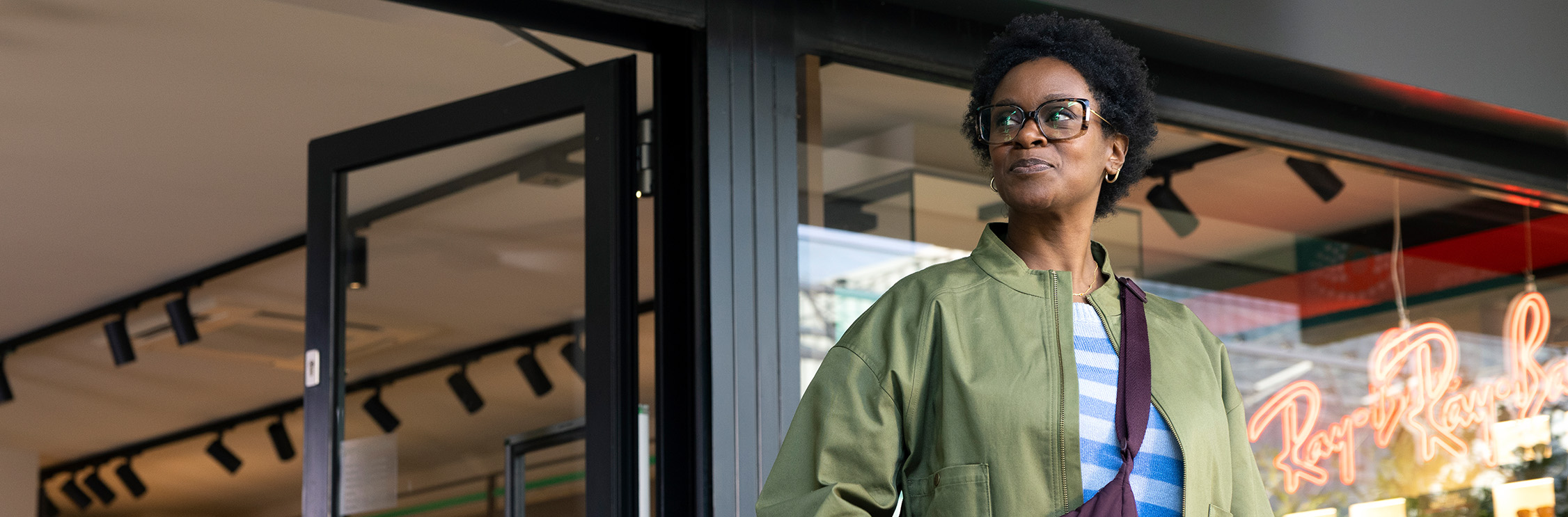 Vrouw met bril loopt de Pearle winkel uit.