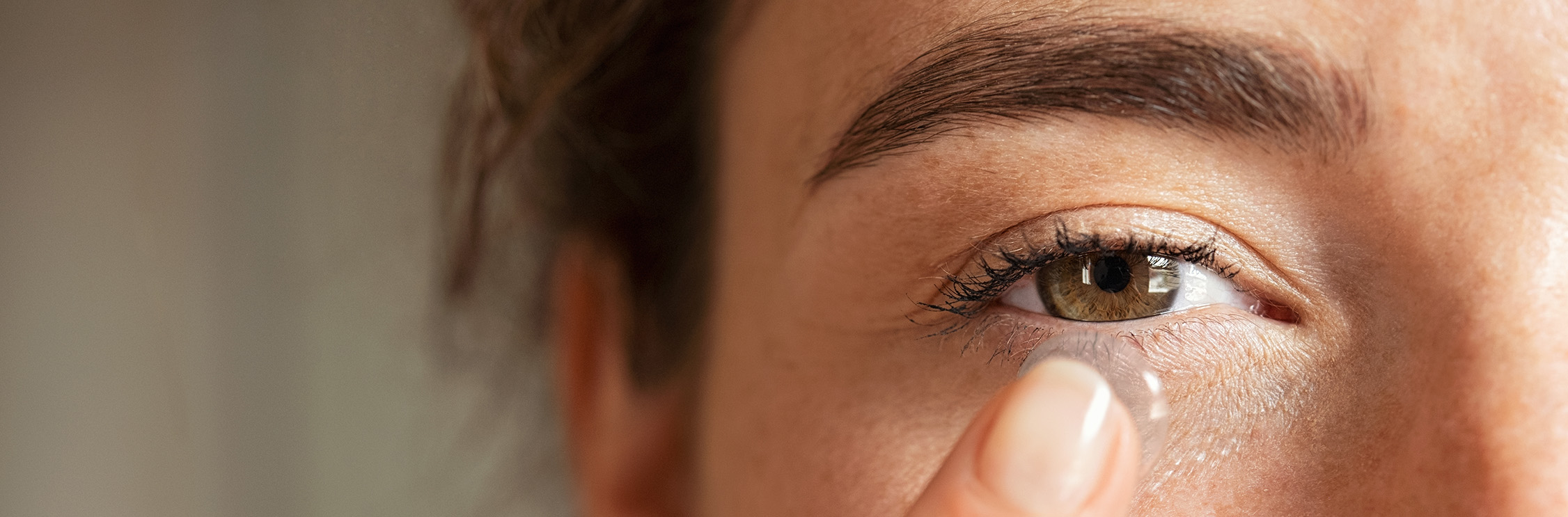 Vrouw doet contactlens in.