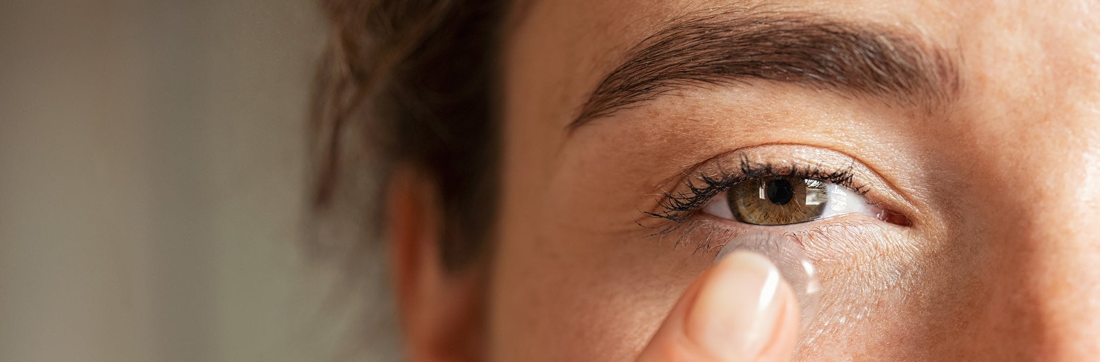 Vrouw doet contactlens in.